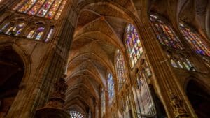Grupo en visita guiada observando el arte de una catedral medieval con interés cultural y enfoque simbólico.
