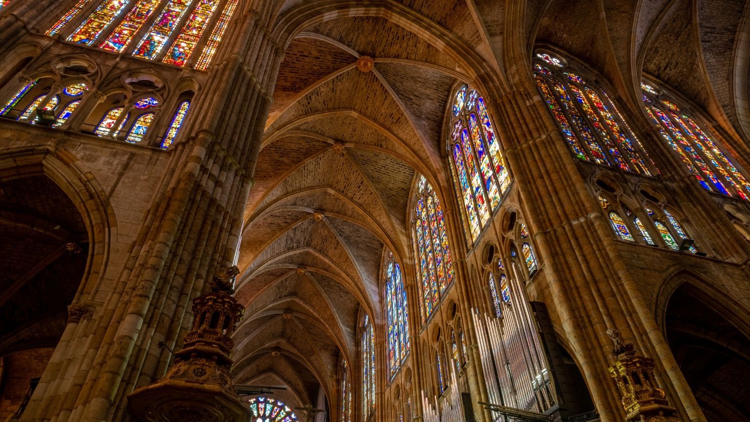 Grupo en visita guiada observando el arte de una catedral medieval con interés cultural y enfoque simbólico.