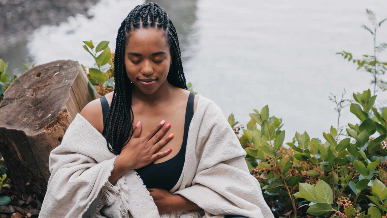 Persona adulta sentada en calma, con ojos cerrados, visualizando metas o meditando, en un ambiente tranquilo que representa claridad mental y crecimiento personal.