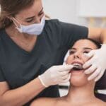 Implante dental en boca realista con prótesis fija – paciente en consulta con odontólogo profesional