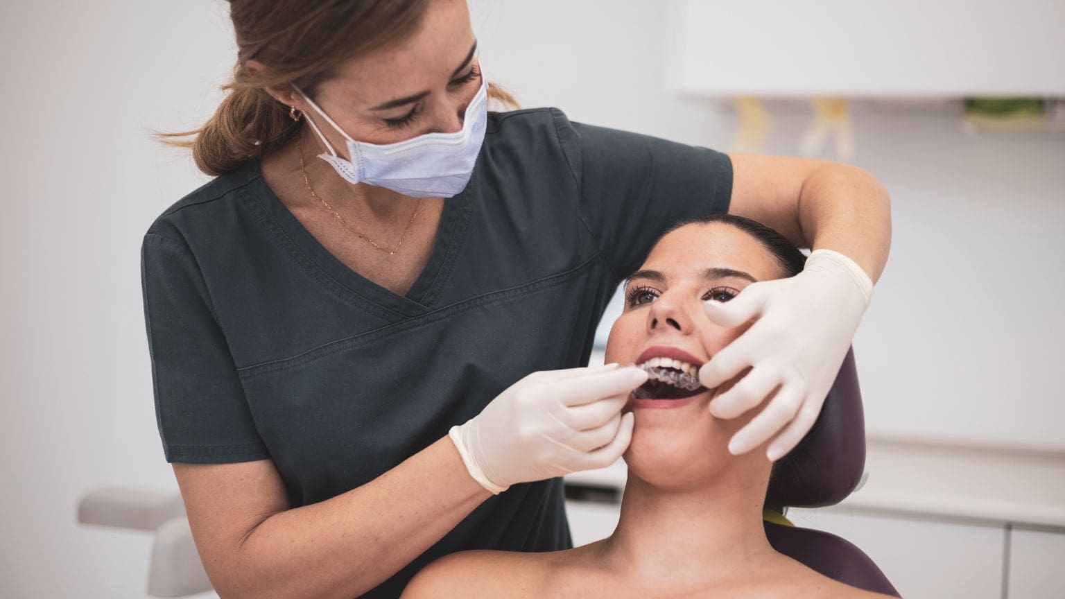 Implante dental en boca realista con prótesis fija – paciente en consulta con odontólogo profesional