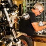 Proceso de reparación de motos de motos clásicas en un taller especializado, con detalles de pintura y ajuste de piezas originales.