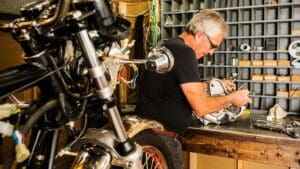 Proceso de reparación de motos de motos clásicas en un taller especializado, con detalles de pintura y ajuste de piezas originales.