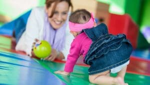 Niña pequeña realizando actividades de estimulación temprana con apoyo terapéutico.