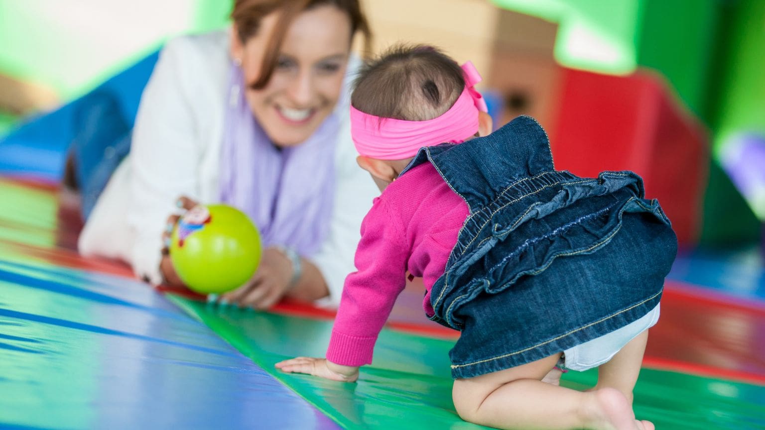Niña pequeña realizando actividades de estimulación temprana con apoyo terapéutico.