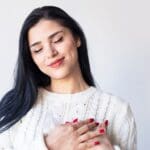Mujer joven sonriendo con expresión serena, símbolo de autoestima, amor propio y bienestar emocional.
