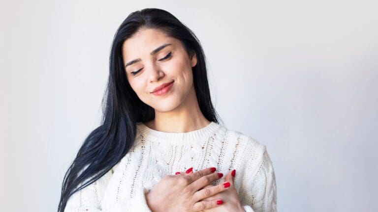 Mujer joven sonriendo con expresión serena, símbolo de autoestima, amor propio y bienestar emocional.