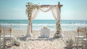 Playa de Ibiza o Formentera decorada para ceremonia LGTBIQ+ oficiada por maestra de ceremonias.