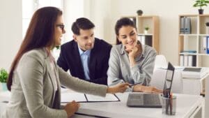 Pareja joven revisando ofertas de pisos en alquiler económicos en la Costa del Sol con asesoría inmobiliaria