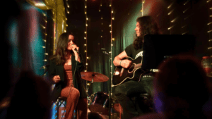 Dúo de música en vivo actuando en eventos en Barcelona, rodeados de público disfrutando de la experiencia cultural.