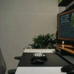 Puesto de trabajo moderno con silla ergonómica reutilizada y escritorio funcional, ejemplo de mobiliario de oficina circular con bajo impacto ambiental.