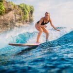 Beginner student in a surf school in Santa Teresa, showing proper surfing techniques.