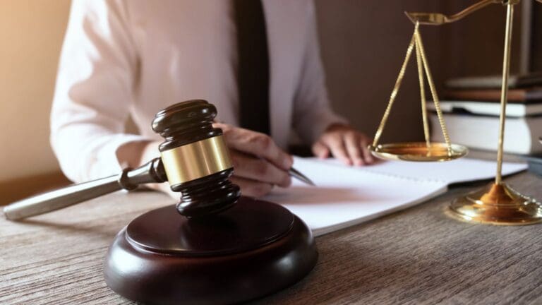 Sala de juicio en España con documentos legales sobre mesa judicial, representando el proceso penal y la instrucción penal.
