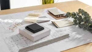 Muestras de materiales y plano arquitectónico sobre mesa de trabajo, representando la fase de planificación previa a una reforma integral de vivienda.
