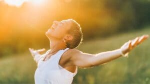 Mujer en conexión espiritual rodeada de naturaleza, expresando calma y empoderamiento interior.