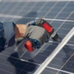 Hombre instalando paneles solares dentro de una reforma integral en Madrid.