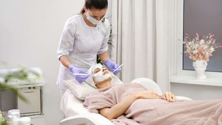 Paciente recibiendo tratamiento facial en clínica estética bajo supervisión médica en un entorno seguro y profesional.