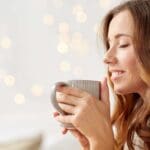 Mujer joven tomando una infusión natural en un entorno tranquilo, representando el bienestar femenino en cada etapa del ciclo.