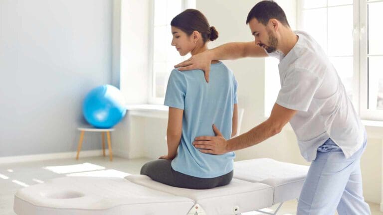 Fisioterapeuta realizando tratamiento de espalda a paciente en centro de fisioterapia en San Lorenzo de El Escorial
