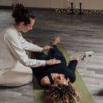 Mujer en etapa postparto realizando ejercicios hipopresivos para recuperar el abdomen y fortalecer el suelo pélvico con acompañamiento fisioterapéutico