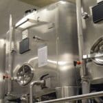 Depósitos de acero inoxidable para aceite en planta de producción, con acabado pulido y equipamiento industrial para conservación óptima del producto.