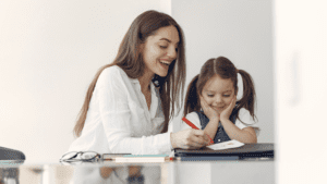 Profesora de inglés ayudando a un niño con sus tareas escolares en casa.
