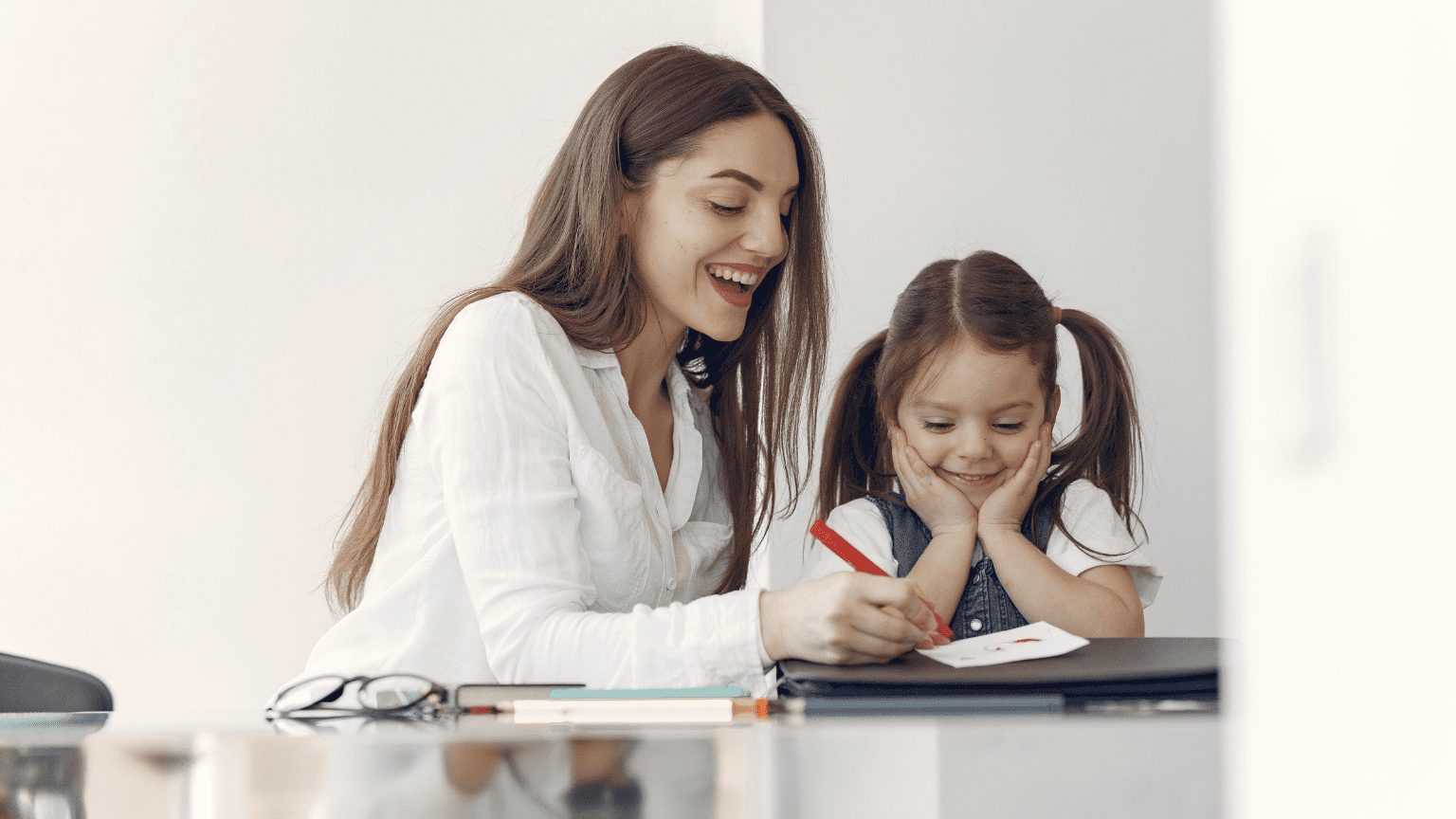 Profesora de inglés ayudando a un niño con sus tareas escolares en casa.