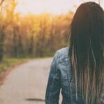 Mujer caminando por un bosque tranquilo, símbolo del enfoque terapéutico de psicólogos Valencia.