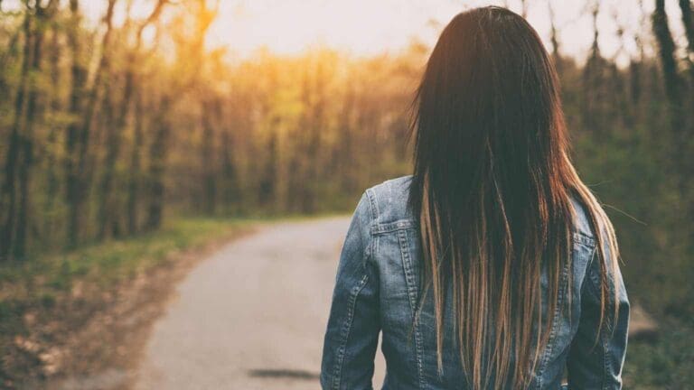 Mujer caminando por un bosque tranquilo, símbolo del enfoque terapéutico de psicólogos Valencia.