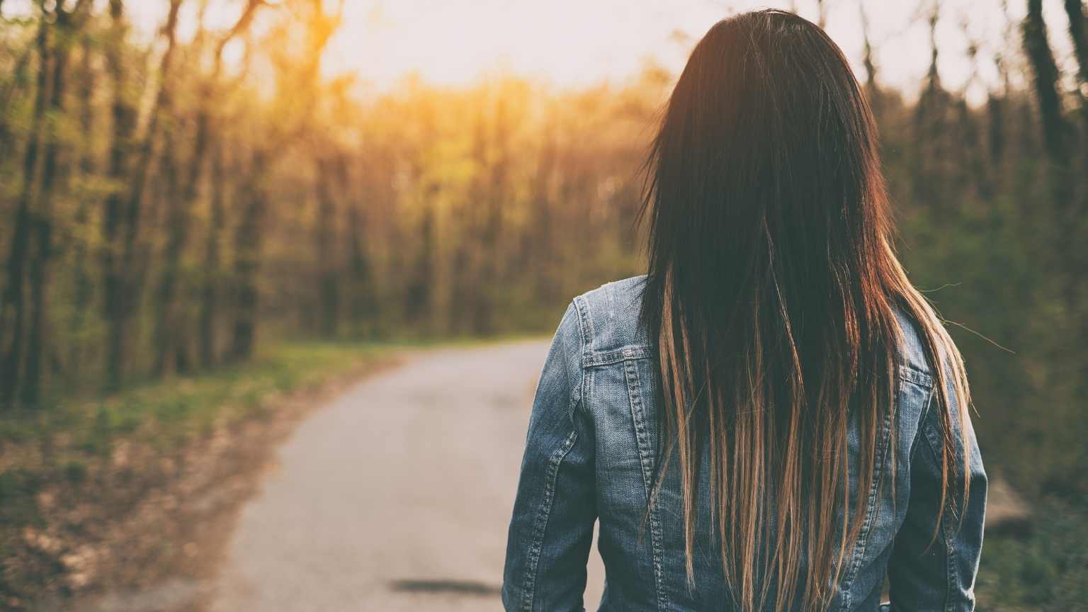 Mujer caminando por un bosque tranquilo, símbolo del enfoque terapéutico de psicólogos Valencia.