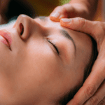 Mujer recibiendo terapia biodinámica craneosacral en un entorno relajante y natural