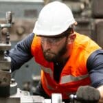 Línea de producción automotriz con operarios gestionando la cadena de suministro