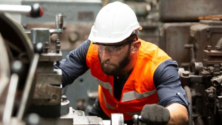 Línea de producción automotriz con operarios gestionando la cadena de suministro