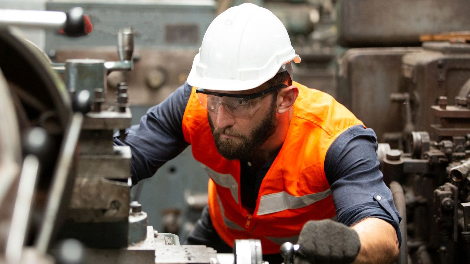 Línea de producción automotriz con operarios gestionando la cadena de suministro