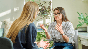 Mujer recibiendo terapia psicológica en una consulta tranquila con apoyo emocional.