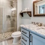 Mampara de ducha corredera de vidrio templado instalada en baño moderno y minimalista