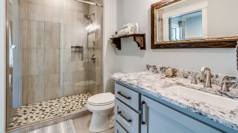 Mampara de ducha corredera de vidrio templado instalada en baño moderno y minimalista