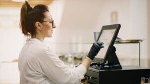 TPV táctil portátil para hostelería en food truck durante evento gastronómico al aire libre.