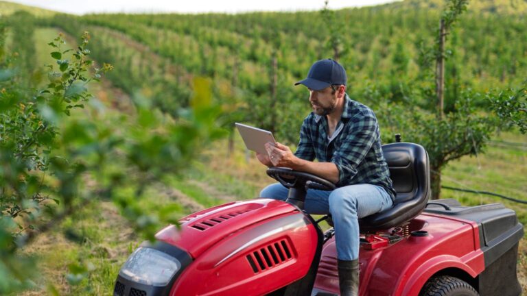 Tractor equipado con sistema GPS trabajando en una plantación agrícola con precisión milimétrica.
