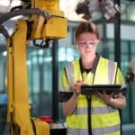 Estudiante de curso online de robótica industrial programando un robot en entorno automatizado