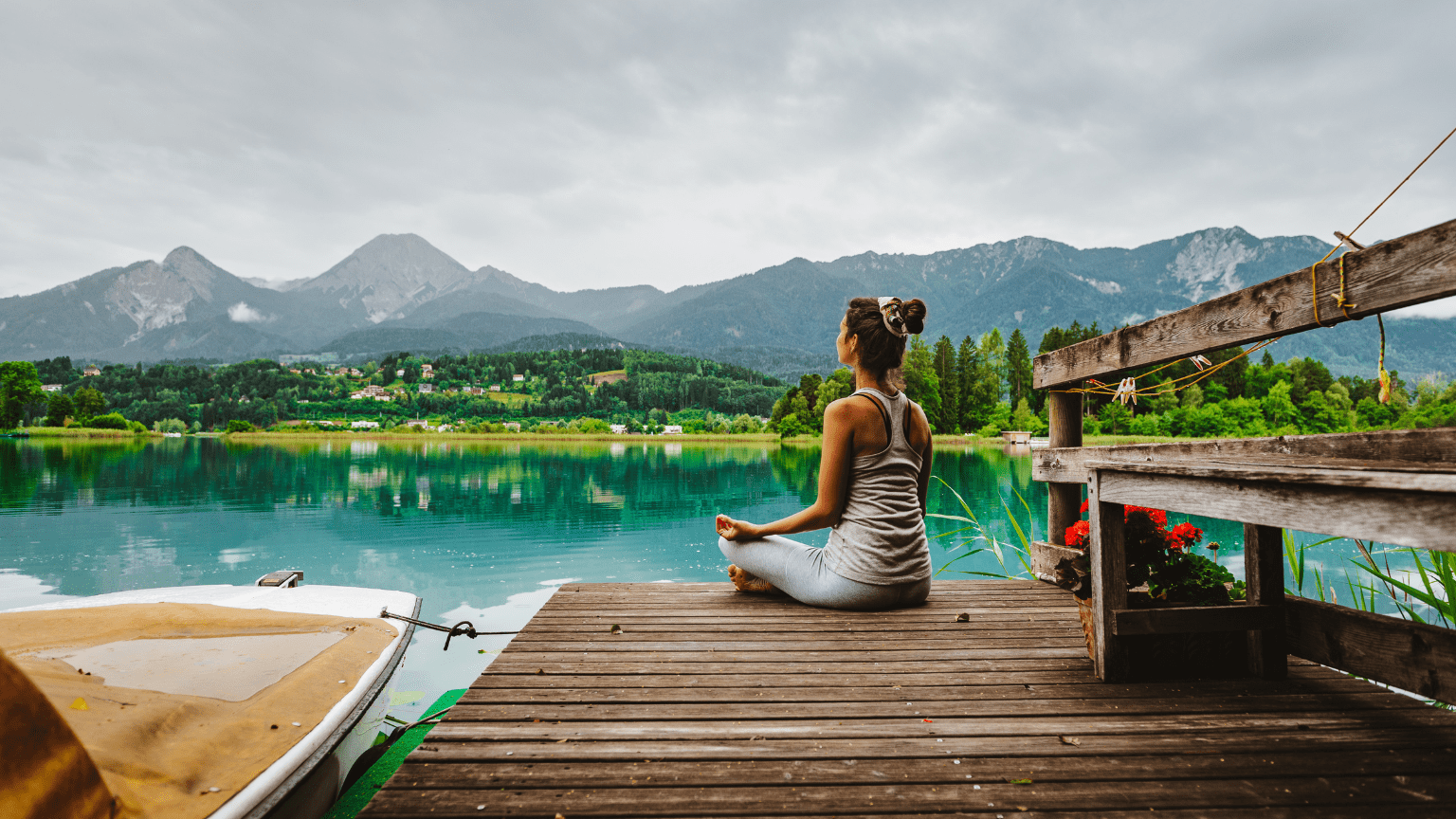 Mujer meditando frente a un lago en plena naturaleza