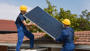 Técnicos de una empresa de instalaciones eléctricas colocando placas solares en un tejado residencial