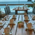 Cena gourmet en restaurante Tenerife al atardecer, con platos elaborados y copas de vino sobre una mesa elegante.