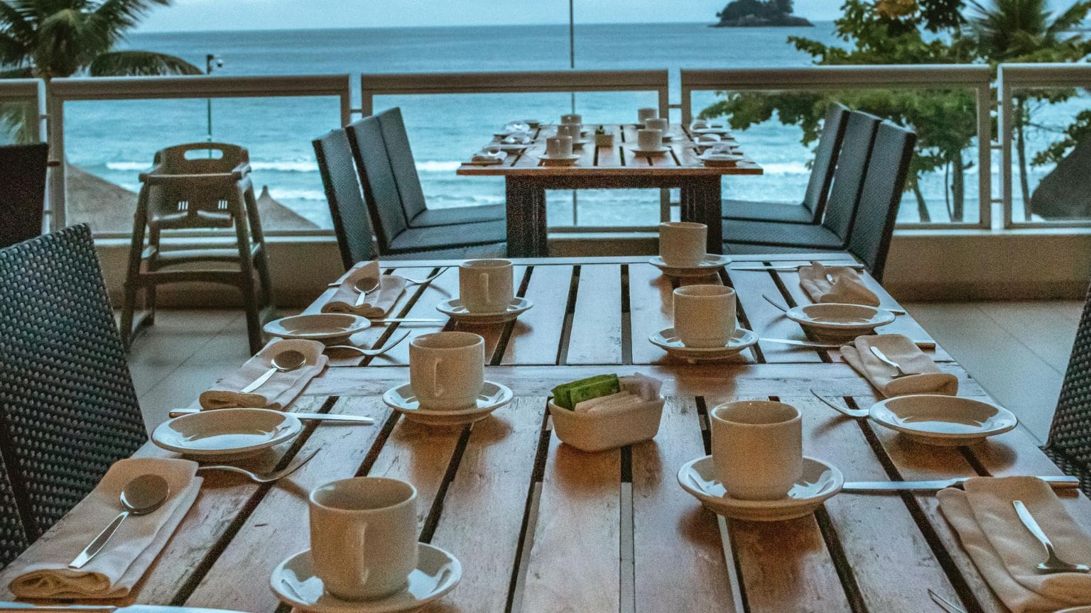 Cena gourmet en restaurante Tenerife al atardecer, con platos elaborados y copas de vino sobre una mesa elegante.
