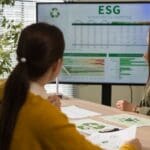 Equipo de consultoría ambiental analizando informe de sostenibilidad ESG en oficina, con gráficos y documentación técnica sobre residuos.