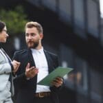 Asesor inmobiliario explicando a un inversor extranjero cómo invertir en propiedades en Barcelona de forma segura y con información clara.