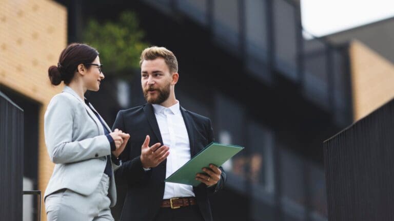 Asesor inmobiliario explicando a un inversor extranjero cómo invertir en propiedades en Barcelona de forma segura y con información clara.