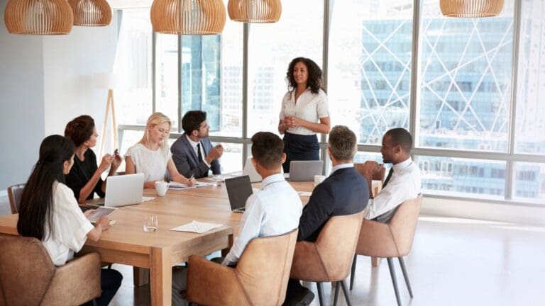 Equipo de oficina desmotivado y desconectado durante una reunión, reflejando una cultura empresarial tensa y poco colaborativa.