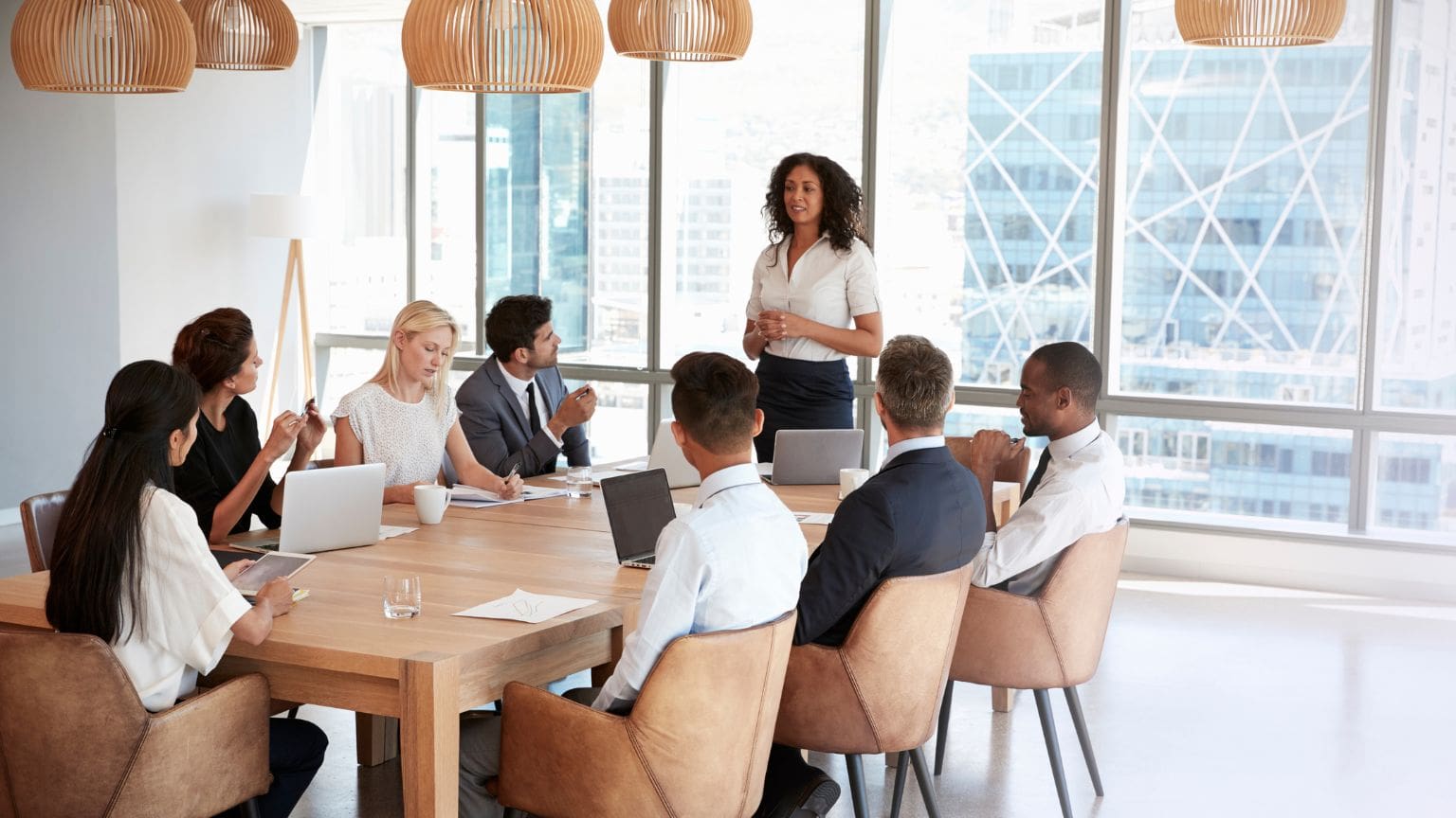 Equipo de oficina desmotivado y desconectado durante una reunión, reflejando una cultura empresarial tensa y poco colaborativa.