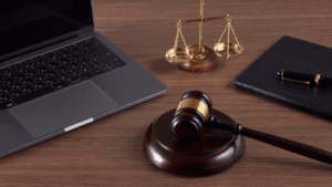 Escritorio de abogado con ordenador portátil, mazo judicial y balanza de la justicia, representando servicios legales y asesoría jurídica en derecho de extranjería en España.